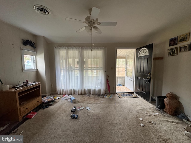 carpeted dining area featuring ceiling fan and a healthy amount of sunlight