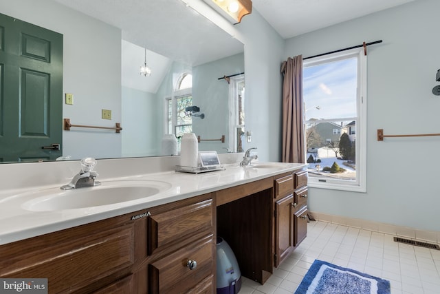 bathroom featuring tile patterned floors, vaulted ceiling, and vanity