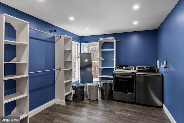 clothes washing area featuring dark hardwood / wood-style flooring and washer and clothes dryer