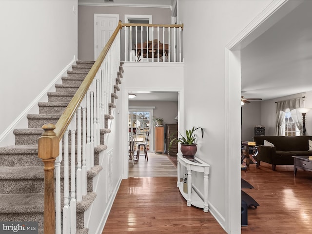 foyer with ceiling fan, hardwood / wood-style floors, and a high ceiling