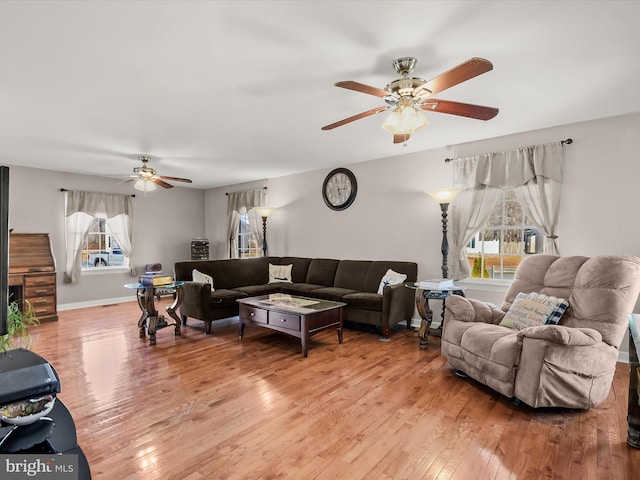 living room featuring wood-type flooring and ceiling fan