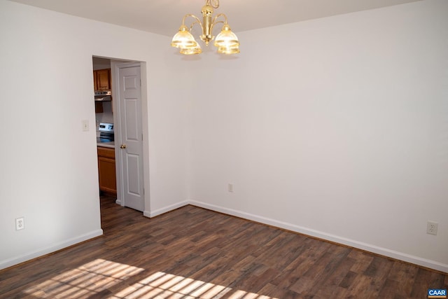 unfurnished room with dark hardwood / wood-style floors and an inviting chandelier