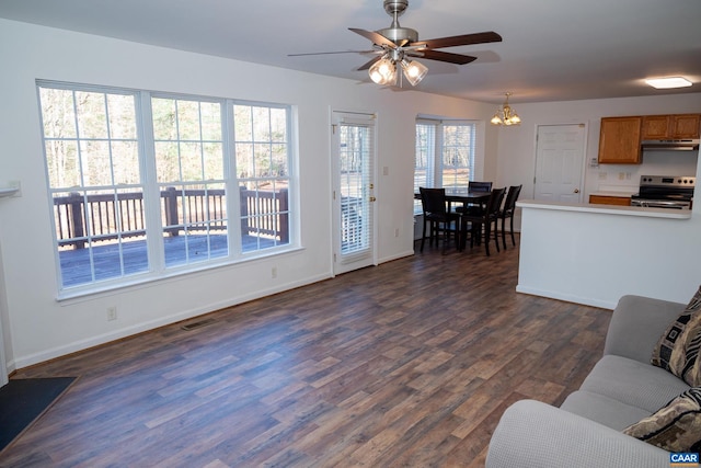 living room featuring dark hardwood / wood-style flooring and ceiling fan with notable chandelier