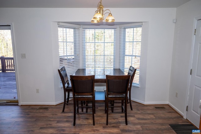 dining room featuring dark hardwood / wood-style floors and an inviting chandelier