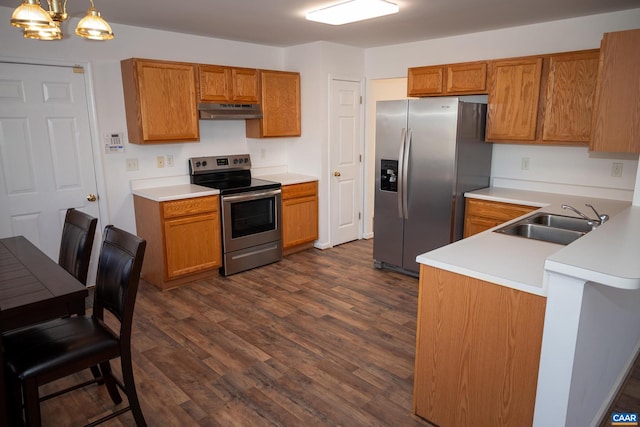 kitchen featuring sink, stainless steel appliances, dark hardwood / wood-style floors, kitchen peninsula, and pendant lighting