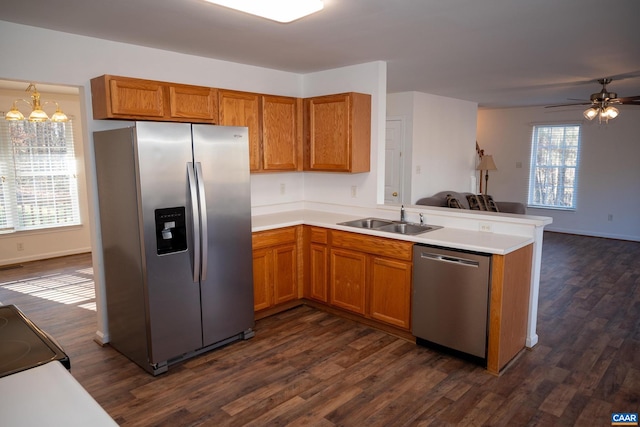 kitchen with plenty of natural light, sink, stainless steel appliances, and ceiling fan with notable chandelier