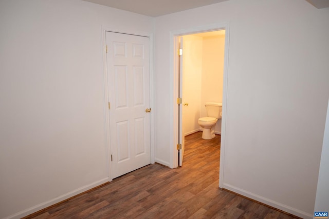 interior space with dark wood-type flooring and ensuite bath