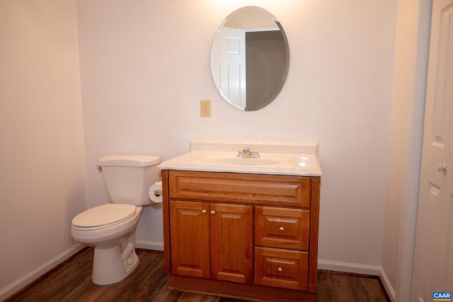 bathroom with hardwood / wood-style flooring, vanity, and toilet