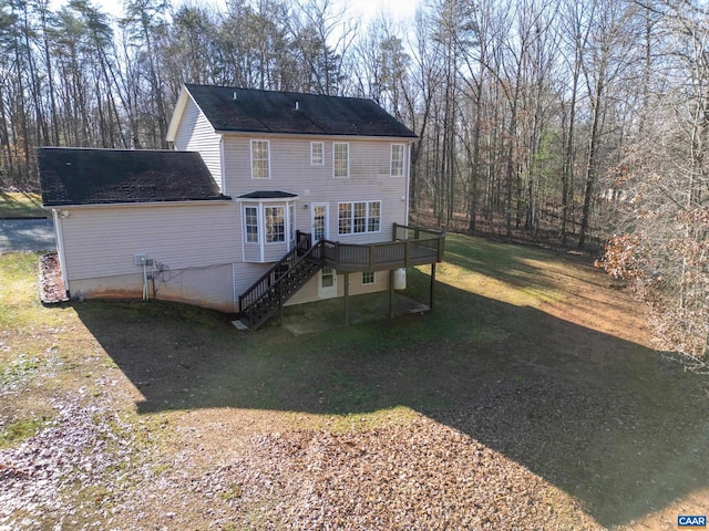 rear view of house featuring a yard and a wooden deck