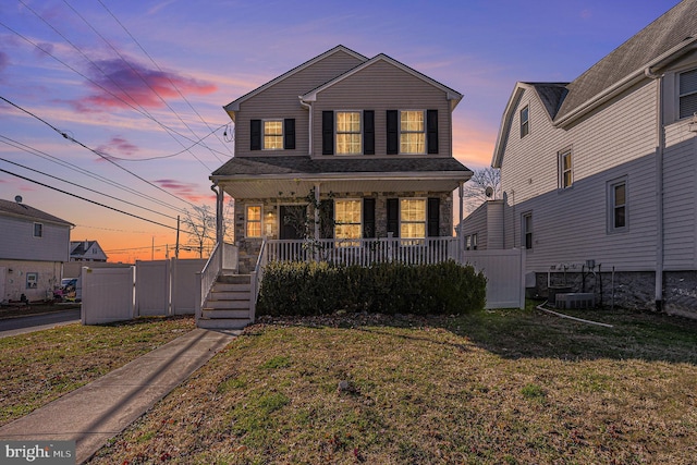 front of property featuring a porch and a lawn