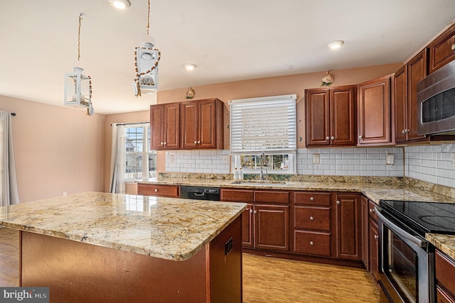 kitchen with decorative backsplash, stainless steel appliances, sink, pendant lighting, and light hardwood / wood-style flooring