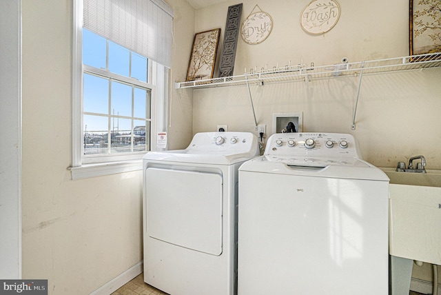 laundry room with separate washer and dryer and sink