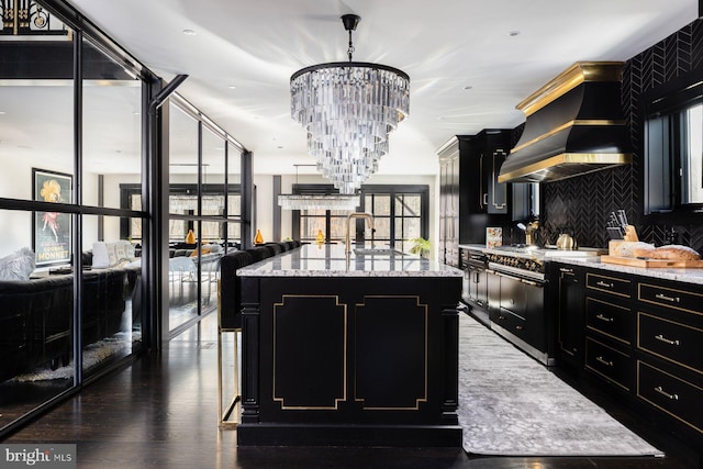 kitchen featuring stainless steel electric range, wall chimney exhaust hood, dark hardwood / wood-style floors, a kitchen island, and a chandelier