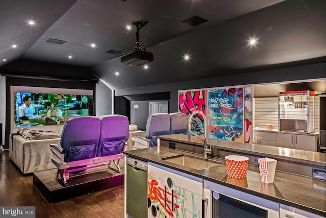 home theater room featuring dark hardwood / wood-style flooring, lofted ceiling, sink, and beverage cooler