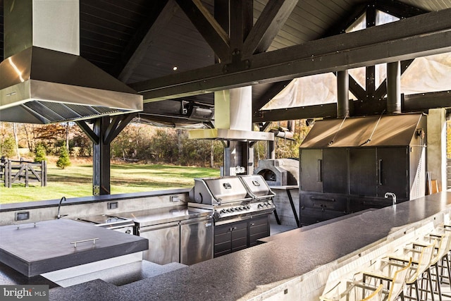 view of patio with a gazebo, grilling area, a bar, and exterior kitchen