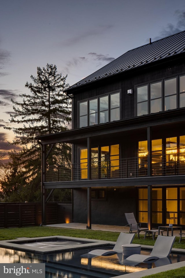 back house at dusk featuring a patio area