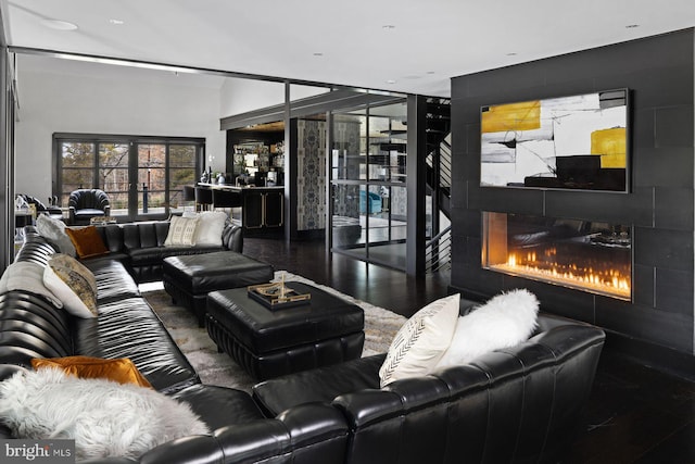 living room with hardwood / wood-style flooring and a tile fireplace