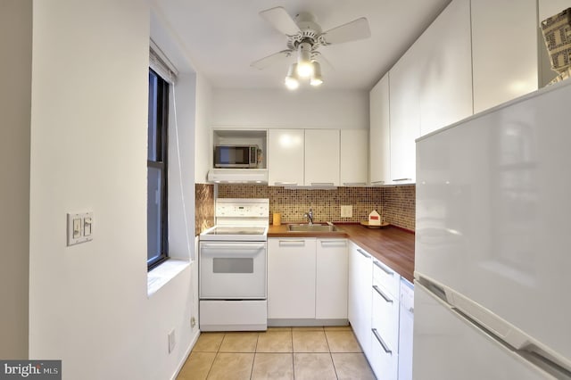 kitchen featuring white appliances, white cabinets, ceiling fan, range hood, and butcher block countertops