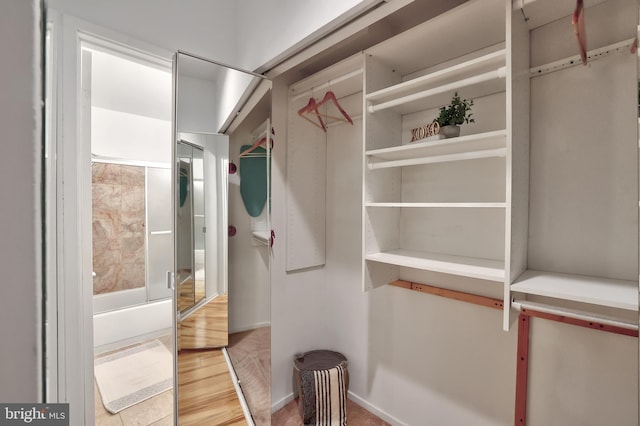 walk in closet with light wood-type flooring