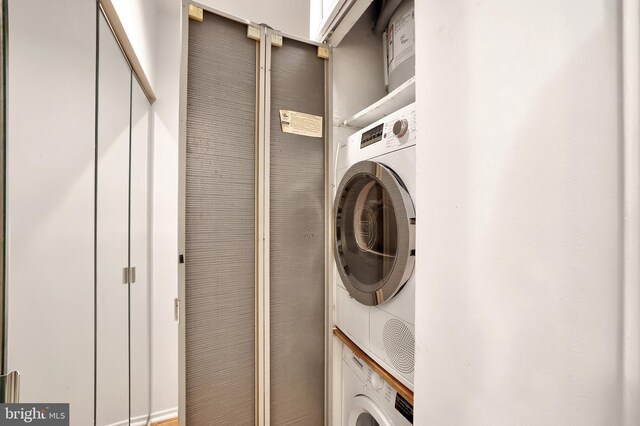 washroom featuring stacked washer / drying machine