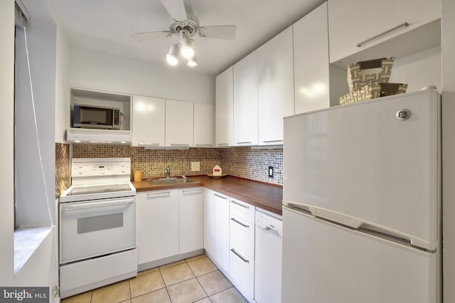 kitchen featuring white appliances, white cabinets, ventilation hood, ceiling fan, and light tile patterned flooring