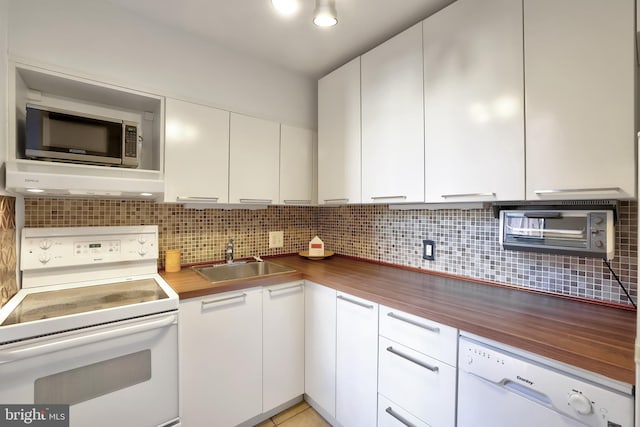 kitchen with white cabinetry, white appliances, sink, and wooden counters