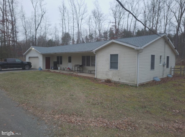 single story home featuring a garage and a front lawn