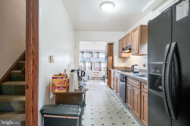 kitchen with black fridge with ice dispenser and stainless steel gas cooktop