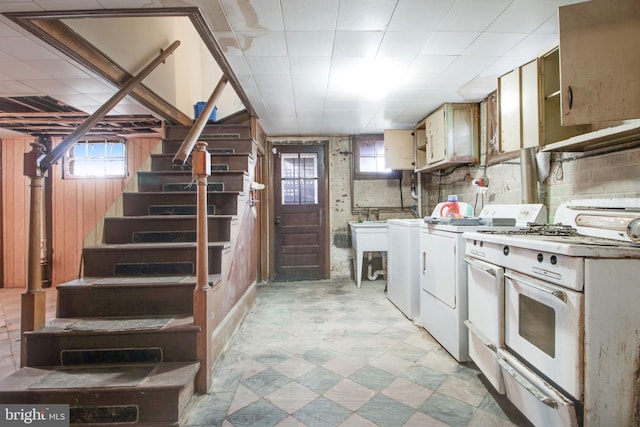 kitchen featuring decorative backsplash, washing machine and dryer, wooden walls, and white gas stove