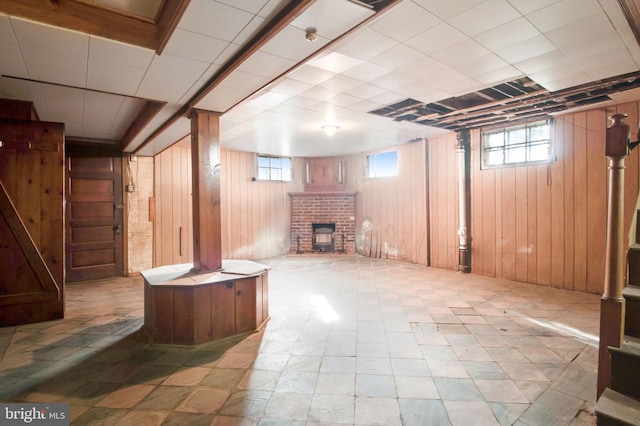 basement featuring wood walls and a fireplace