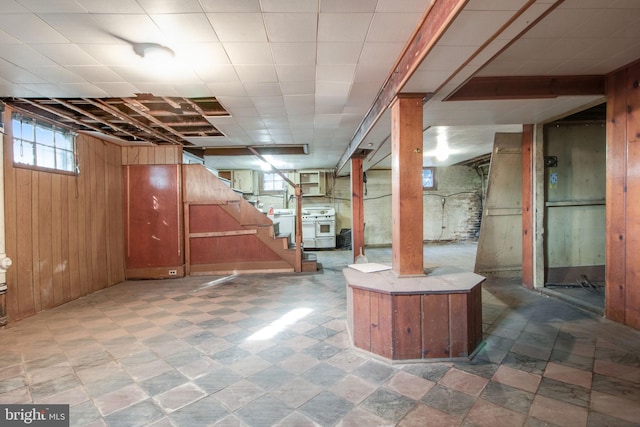 basement with washer / clothes dryer and wooden walls