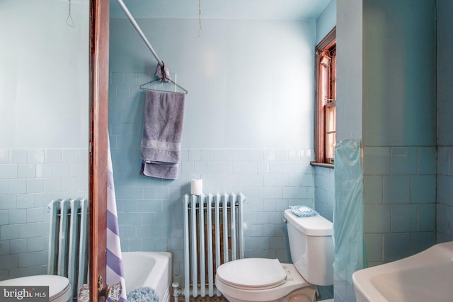 bathroom featuring radiator, tile walls, and toilet