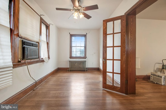 unfurnished room with radiator, ceiling fan, hardwood / wood-style floors, and cooling unit