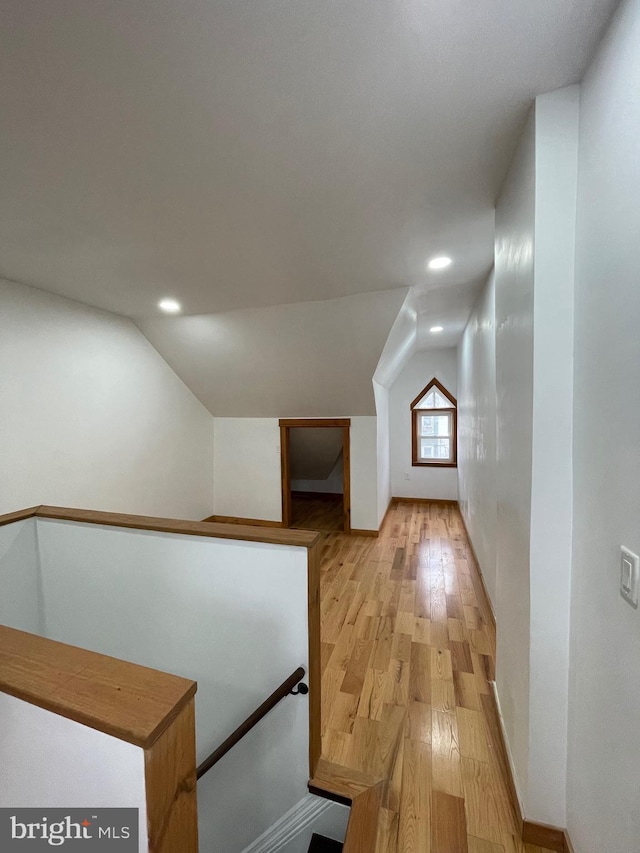 additional living space with lofted ceiling and light wood-type flooring