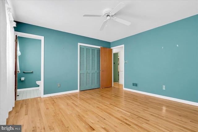 unfurnished bedroom with connected bathroom, light hardwood / wood-style floors, a closet, and ceiling fan