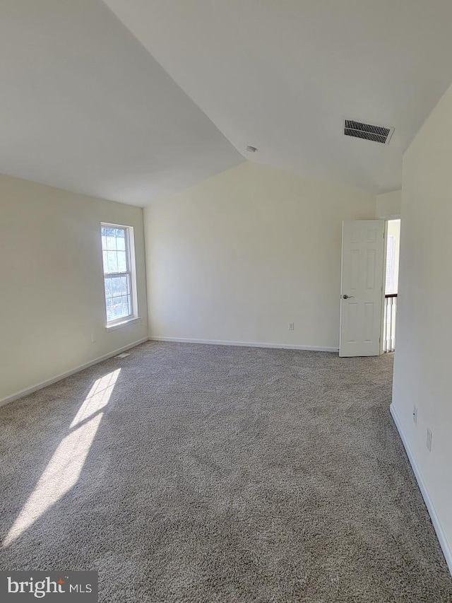 unfurnished room featuring carpet floors and lofted ceiling