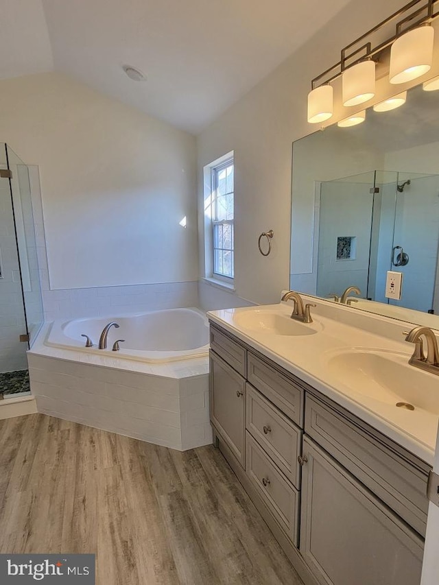 bathroom featuring vanity, hardwood / wood-style floors, plus walk in shower, and lofted ceiling