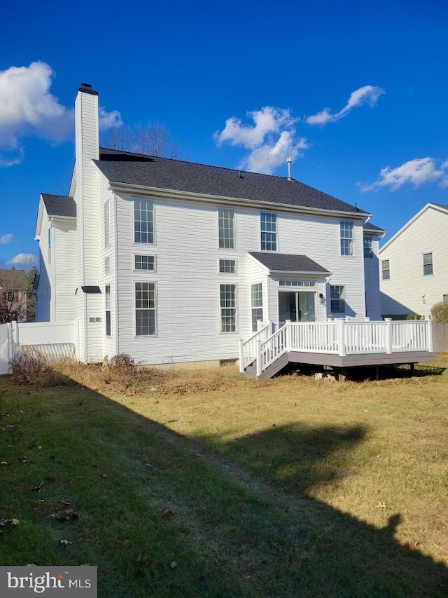 back of property featuring a yard and a wooden deck