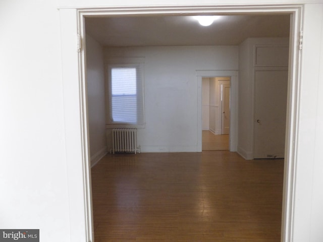 empty room featuring hardwood / wood-style flooring and radiator