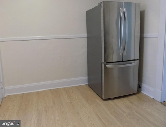 kitchen with stainless steel fridge and light hardwood / wood-style floors