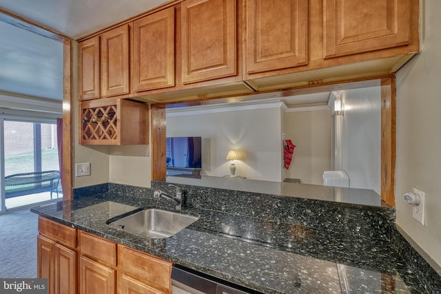 kitchen featuring sink, dark stone countertops, ornamental molding, dishwasher, and carpet