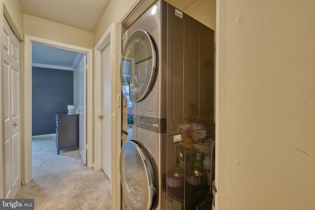 laundry room featuring light carpet, ornamental molding, and stacked washer / dryer