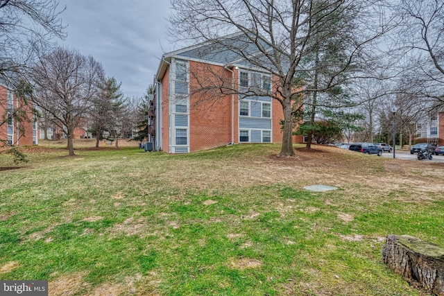 view of property exterior featuring central AC unit and a lawn