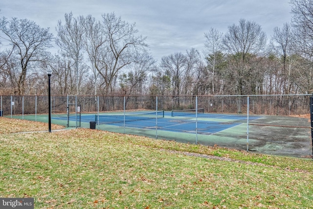 view of tennis court with a yard