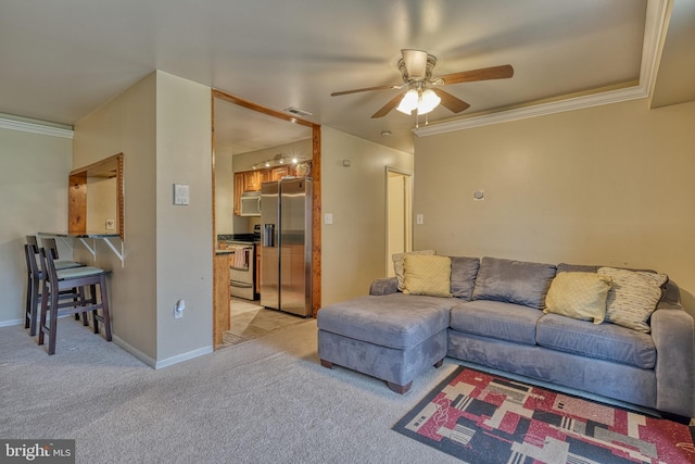 living room with crown molding, light colored carpet, and ceiling fan