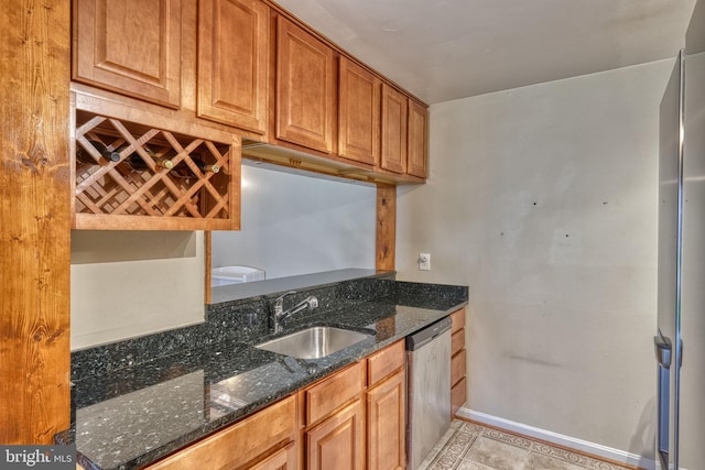 kitchen featuring light tile patterned flooring, dark stone counters, dishwasher, and sink