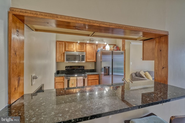 kitchen featuring sink, dark stone counters, kitchen peninsula, stainless steel appliances, and beam ceiling