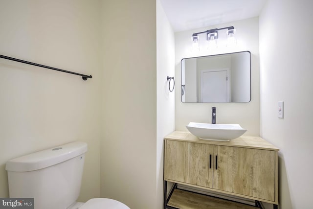 bathroom with hardwood / wood-style floors, vanity, and toilet