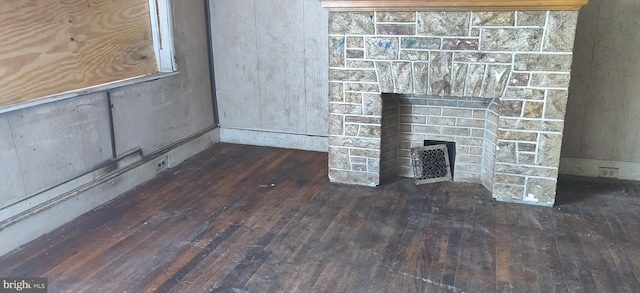 interior details featuring wood-type flooring and a stone fireplace