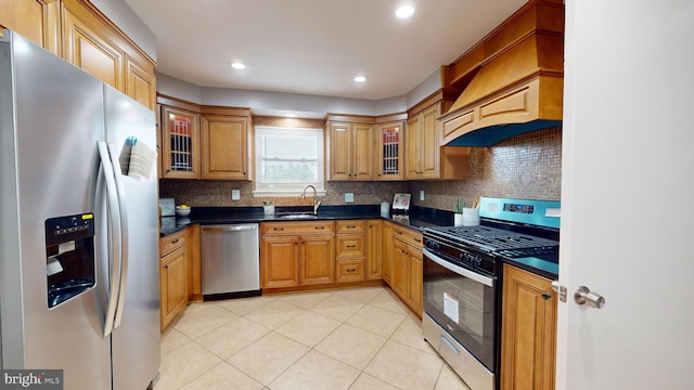 kitchen featuring sink, stainless steel appliances, tasteful backsplash, light tile patterned flooring, and custom range hood